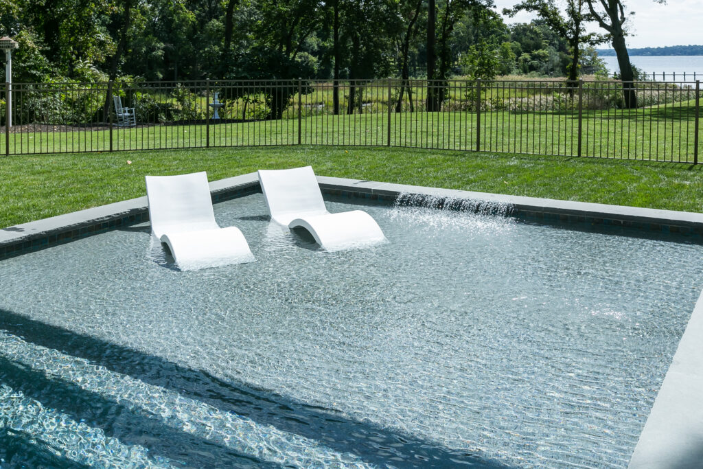 custom backyard pool with sun shelf